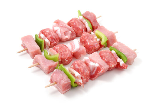 Spiedini di carne di maiale crudi isolati su sfondo bianco