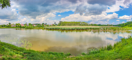 Fototapeta premium Landscape with a lake and clouds in the sky in the summer season