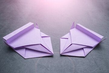 Two origami paper racing cars on gray background