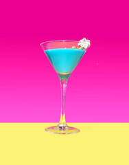 A modern blue cocktail with a white flower with bright magenta background and warm yellow bottom. One and only master optimistic concept.