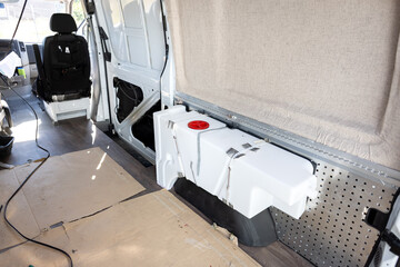 Water tank inside an empty camper van
