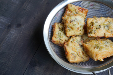 The flour fried tempeh is drained so that the remaining cooking oil is reduced              