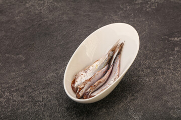 Anchovies in the bowl served basil leaves