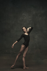 Young and graceful ballet dancer isolated on dark background. Art, motion, action, flexibility,...