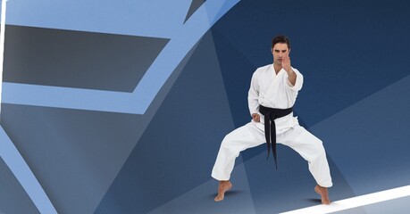 Caucasian male martial artist with black belt against abstract shapes on blue background