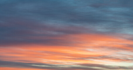 Colorful photo of sky highlighted by red orange sunset on dark blue sky, soft colors. Nice real...