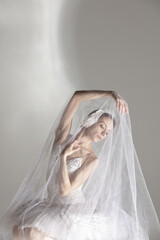 Young graceful balerina in image of white swan in art performance isolated on gray white background. © Lustre Art Group 