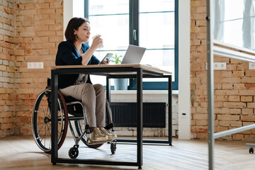 Young disabled business woman in wheelchair working