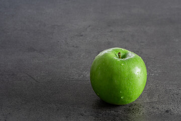 Grüner Apfel auf grauer Struktur