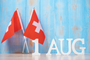 Wooden text of August 1st with miniature Switzerland flags. Switzerland National Day and happy celebration concepts - obrazy, fototapety, plakaty