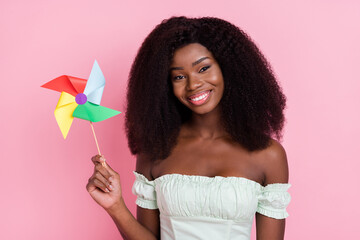 Fototapeta na wymiar Photo of young african woman happy positive smile hold windmill toy isolated over pink color background