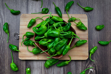 Top view of freshly harvested green peppers on a rustic wooden table