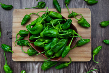 Top view of freshly harvested green peppers on a rustic wooden table