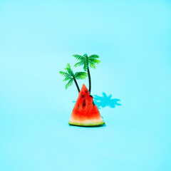 A slice of watermelon with a palm tree on a summer beach. Minimal and simple composition.