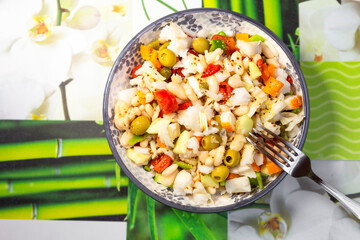 white beans and codfish salad in round plate with bell pepper,onion and olives