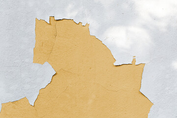 Cracked white paint on concrete wall background and see old yellow painted concrete inside