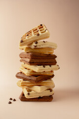 Waffle tower, made of chocolate, traditional and cholotale chips, brown background