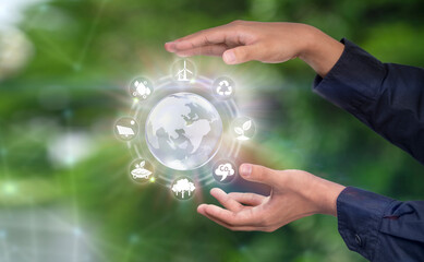 Hand holding a digital world with eco icon on blur green nature background, Environmental, friendly and sustainable environment, eco earth day concept.