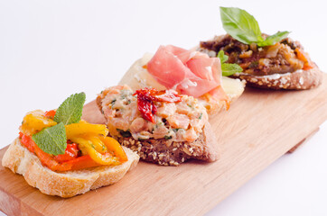 Appetizing bruschetta on a white background..Baguette with vegetable and meat filling. Delicious bruschetta for a hearty snack