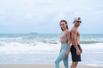 Young couples stand back and forth after exercising.
together on the beach 