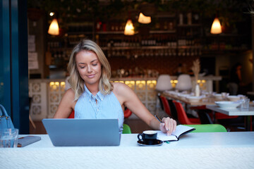 Young woman freelancing from her laptop at cafe