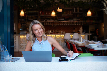 Young woman freelancing from her laptop at cafe