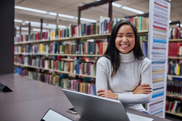 Young female Asian student working on her laptop at university library