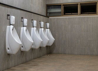 Men's room with white porcelain urinals in line