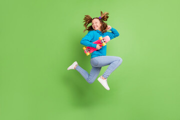 Fototapeta na wymiar Full body photo of ponytail brown haired little girl jump wear casual street clothes jump skater run isolated on green color background