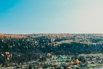 Mountains, forest and village in autumn