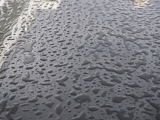Lots of water droplets on a dark glossy surface. Full screenphoto