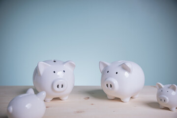 Family white piggy bank on old wood looking at green background. Father and mother little piggyback training save money for growth in the future. Concept family saving money for the future.