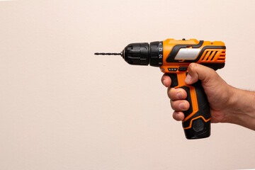 Hand with cordless drill with small drill bit