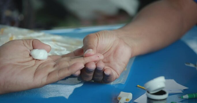 Doctor making blood sugar test with lancet glucometer in fingertip.