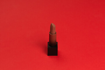 Red lipstick on a red background. Makeup.
