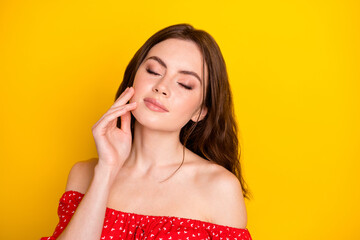 Fototapeta premium Portrait of charming lady closed eyes hand fingers touch cheek perfection isolated on yellow color background