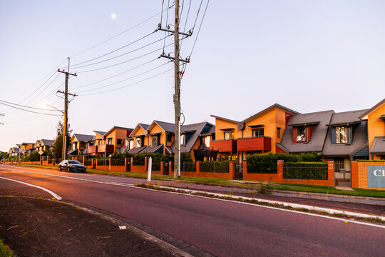 Street scene at dusk of power poles and wires and row of apartments