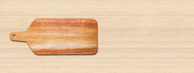 Wooden cutting board isolated on wood background. Horizontal banner