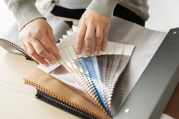 female designer with fabric color samples choosing textile for curtains - obrazy, fototapety, plakaty
