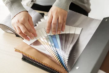 Fototapeten female designer with fabric color samples choosing textile for curtains © Piman Khrutmuang