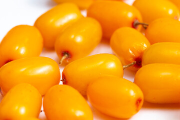 Ripe sea buckthorn berries close-up sprinkled on white