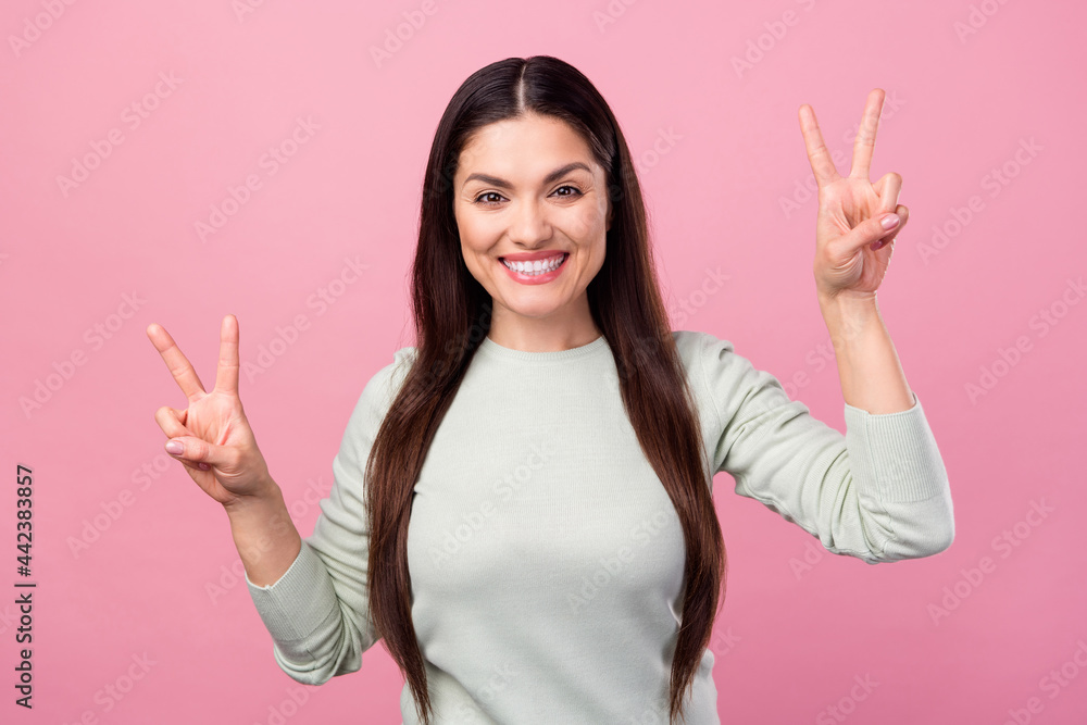 Sticker Photo of positive nice happy young woman show v-sings smile hello cool isolated on pastel pink color background