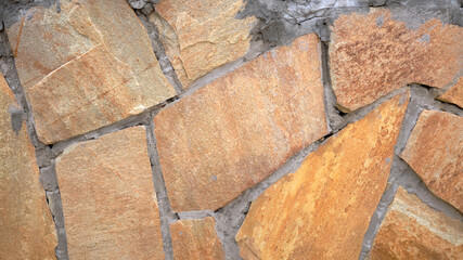 Fototapeta premium Fragment of a wall from a chipped stone, stone wall texture. decorative stone, different colors.