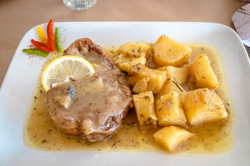 Braised lamb in gravy served with potatoes at the restaurant. Traditional Greek dish.