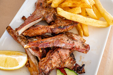 Grilled lamb chops served with fries in restaurant. Traditional Greek dish.