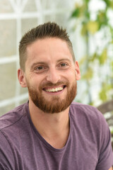 Fototapeta premium young bearded man smiling with purple clothes