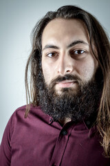 portrait of a young middle eastern businessman with beard and long hair