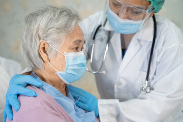 Doctor checking Asian senior or elderly old lady woman patient wearing a face mask in hospital for protect infection Covid-19 Coronavirus.