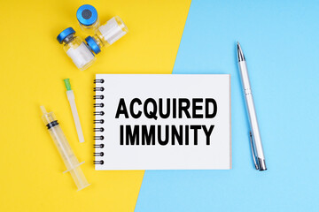 A syringe, ampoules and a notebook with the inscription - ACQUIRED IMMUNITY