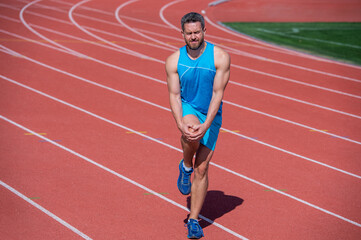 Obraz premium male runner flex muscles because of sport trauma after workout, sport injury